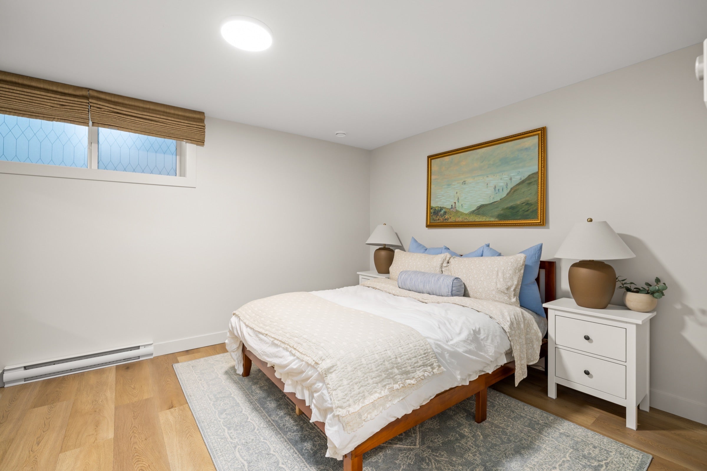 Queen bedroom with bedside tables and woven window shades