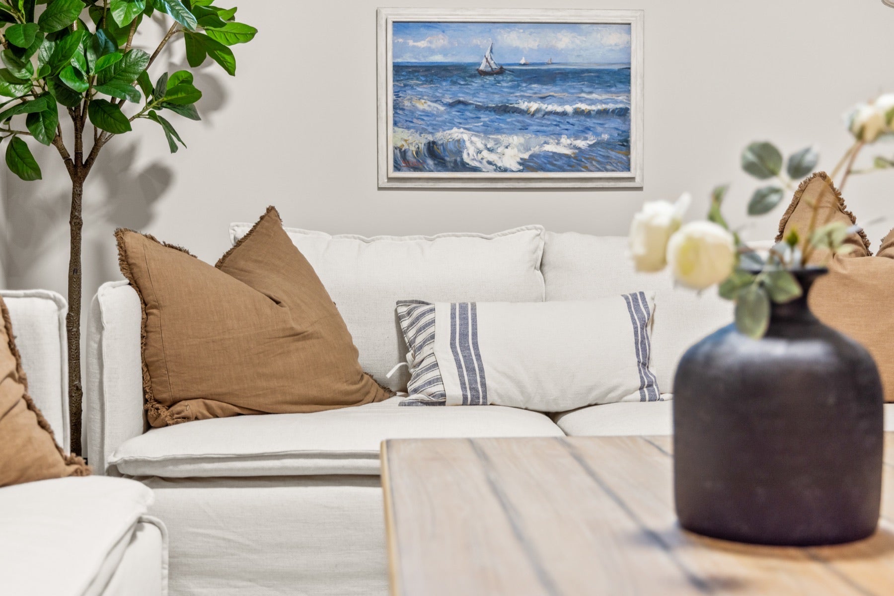 Furnished living room sofa with coastal artwork